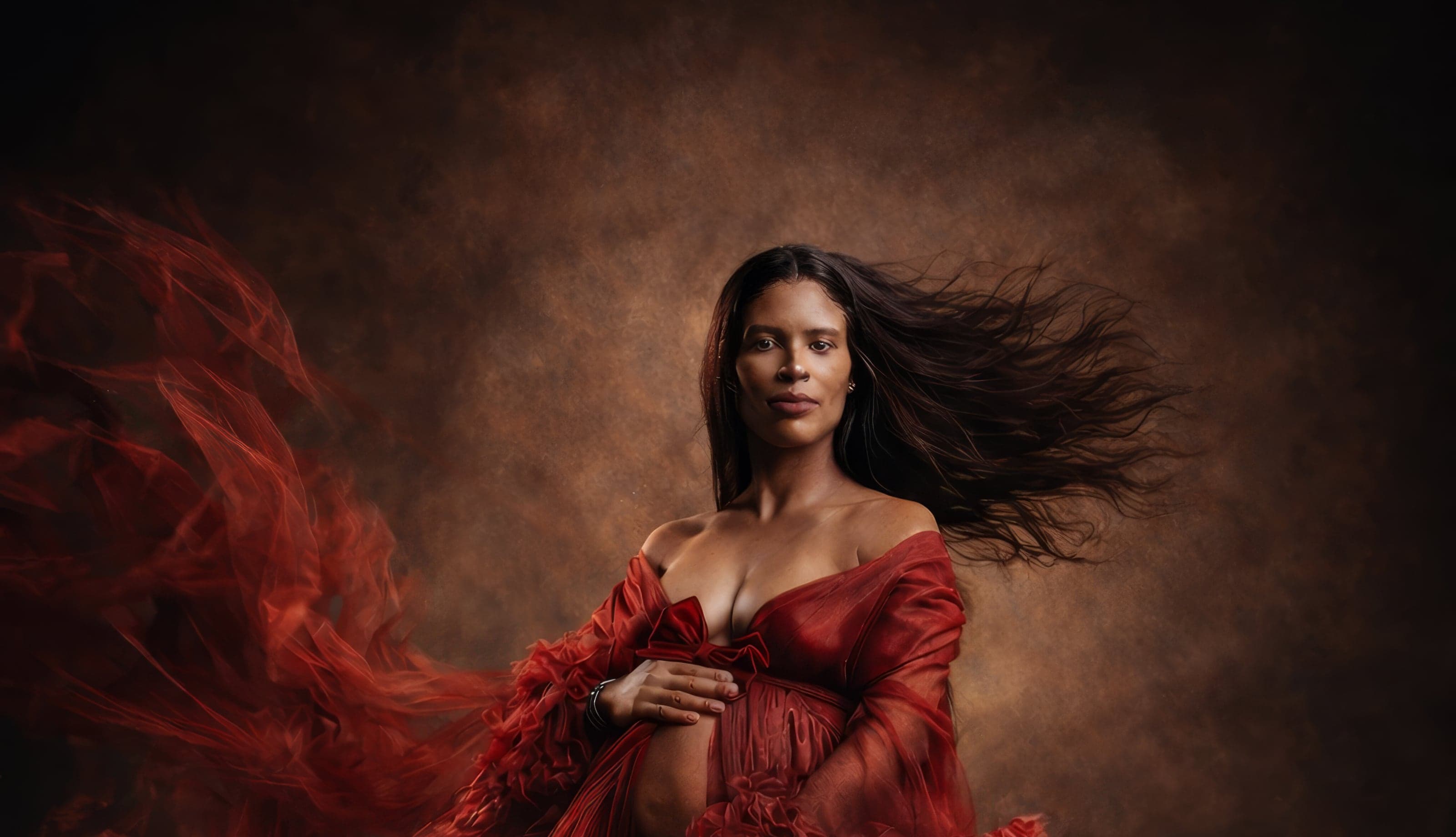 Fine-art maternity portrait in a flowing red gown