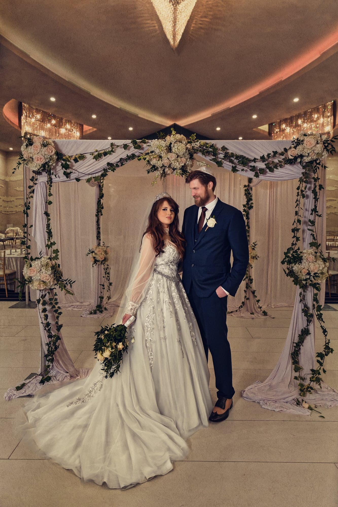Kim and Brent together beneath their floral ceremony canopy