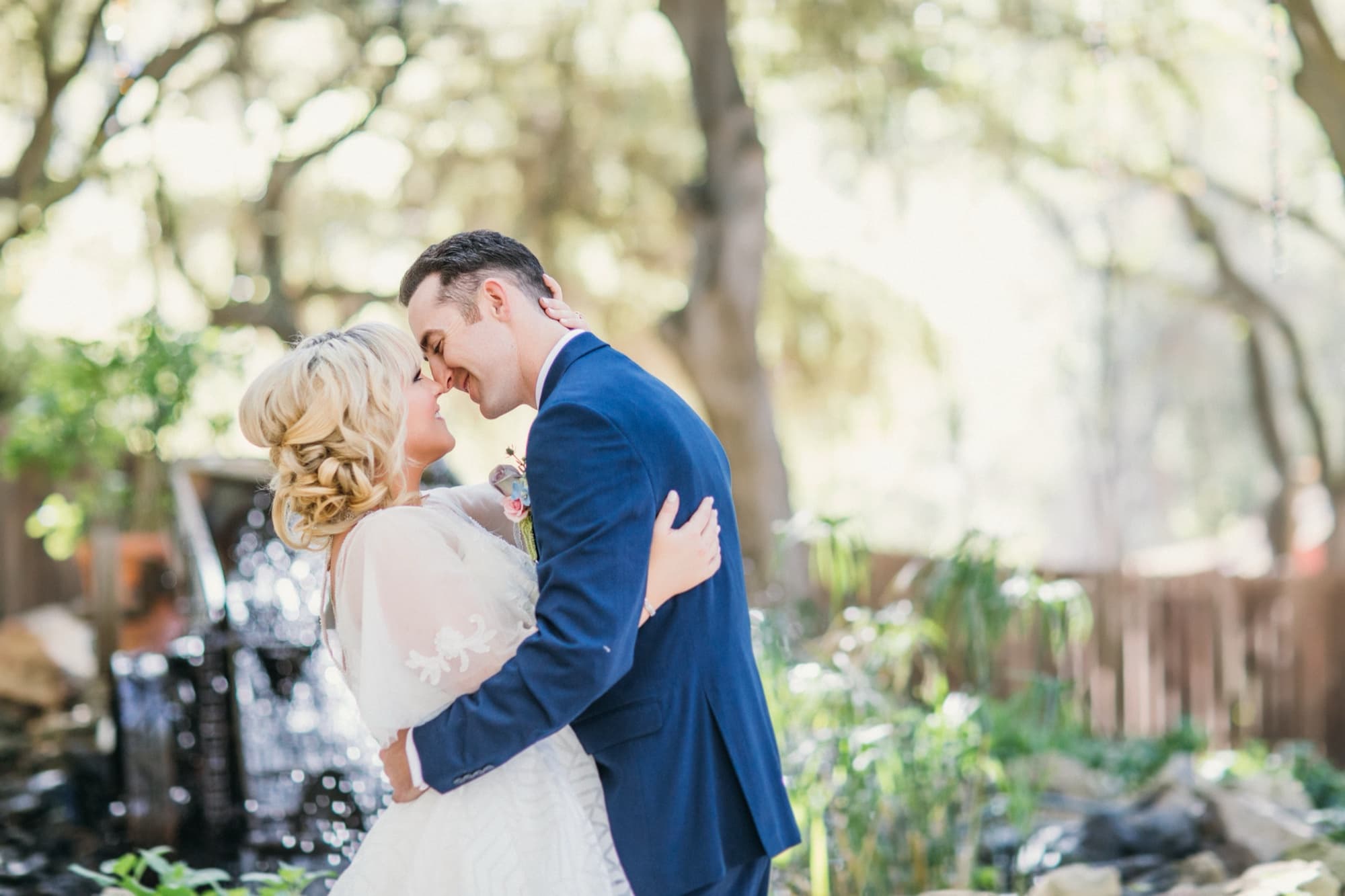 Bride and groom embracing in front of the waterfall at Calamigos Ranch in Malibu, photographed by Michael Anthony Photography