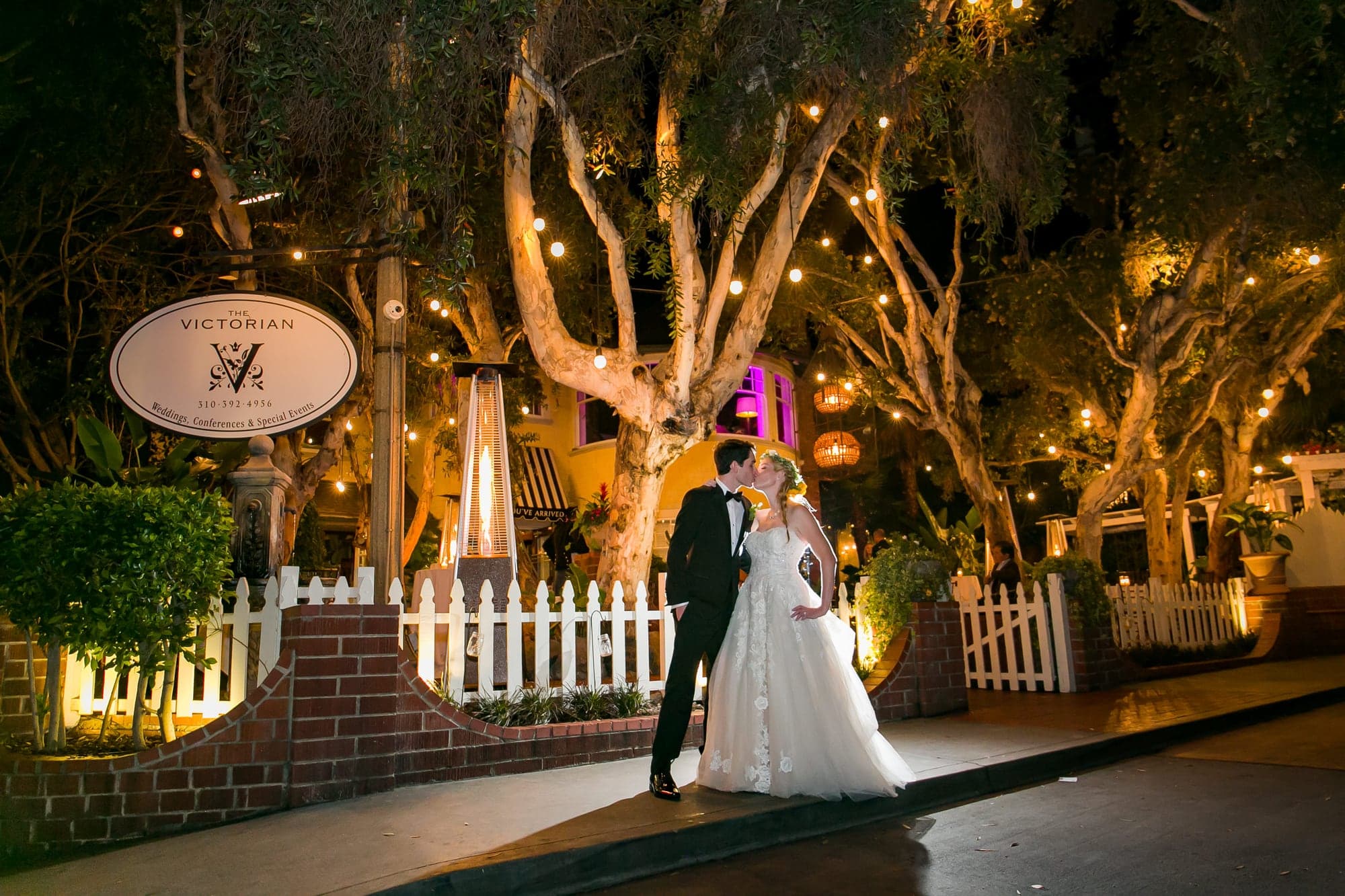 Tara and Justin beneath illuminated trees at Calamigos Ranch