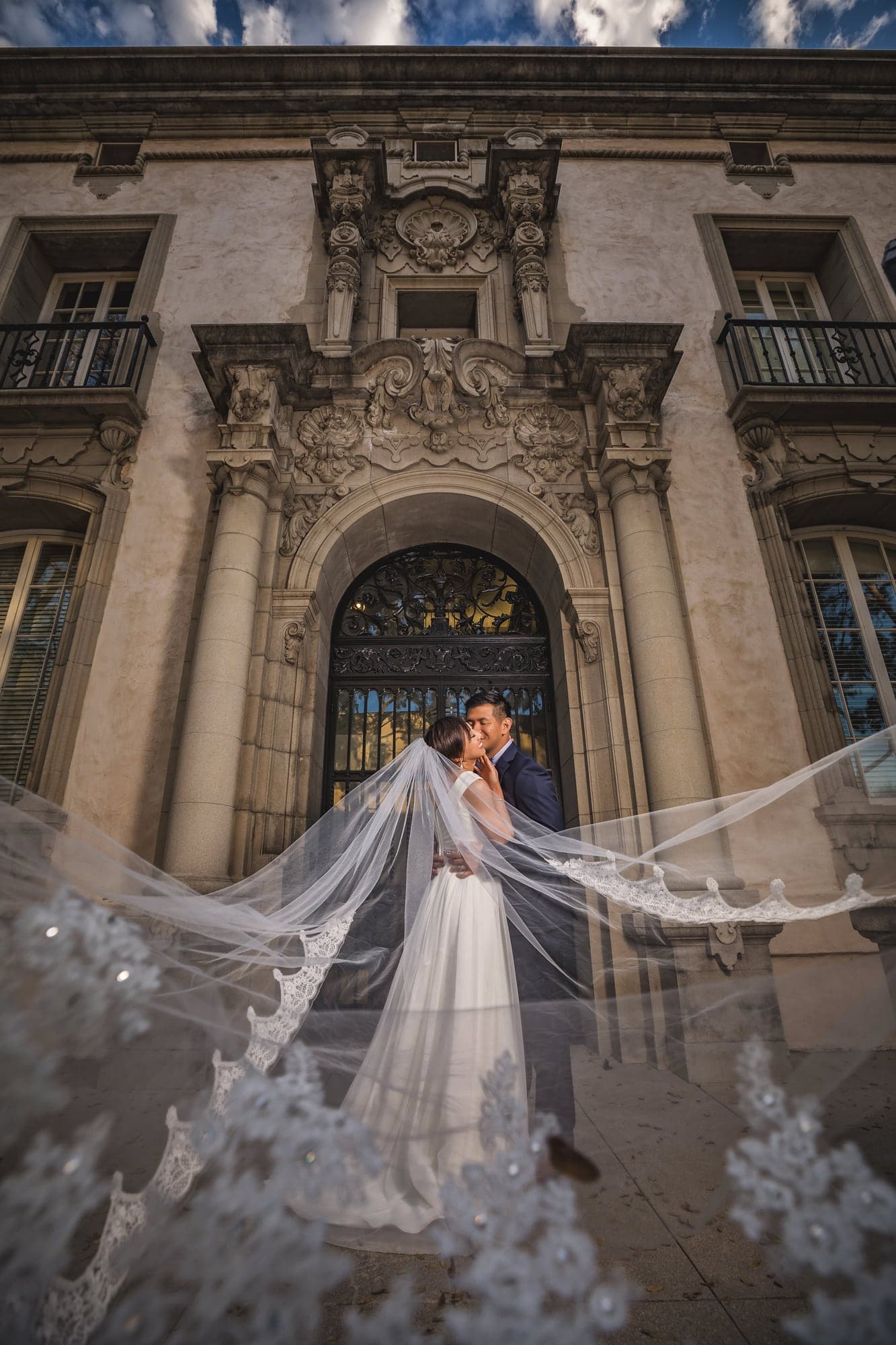 Wedding couple framed by Pasadena architecture and a flowing veil