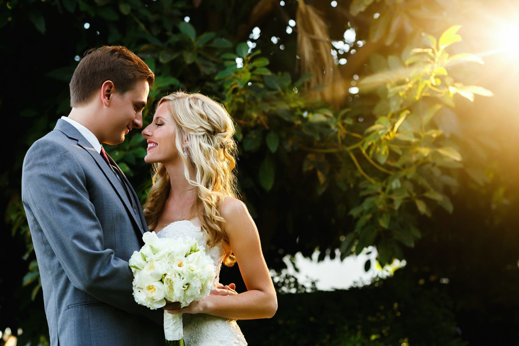 Newlyweds sharing a sunlit portrait at Christmas House Inn