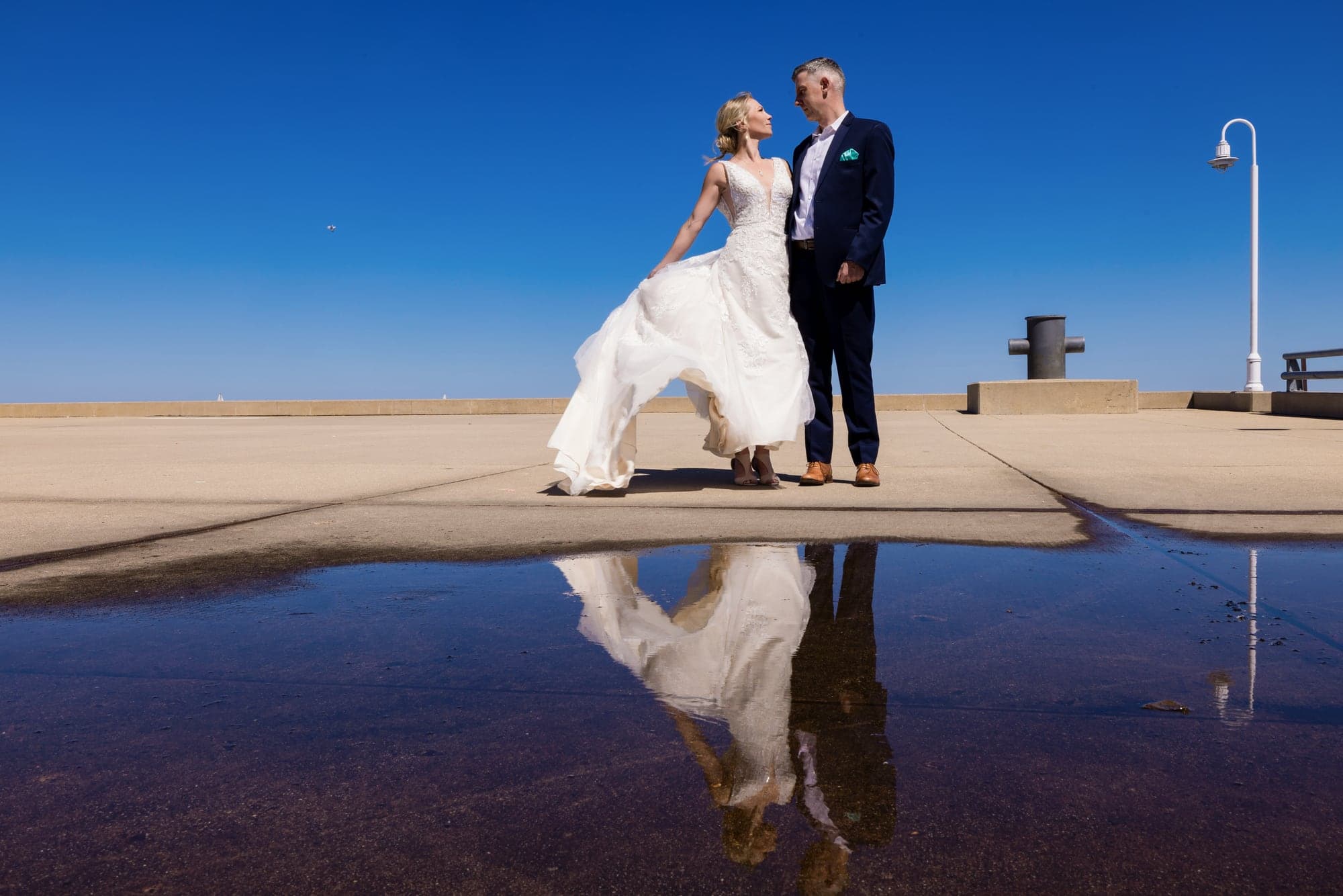 Brittany and Troy reflected in a rooftop pool during their Milwaukee wedding portraits