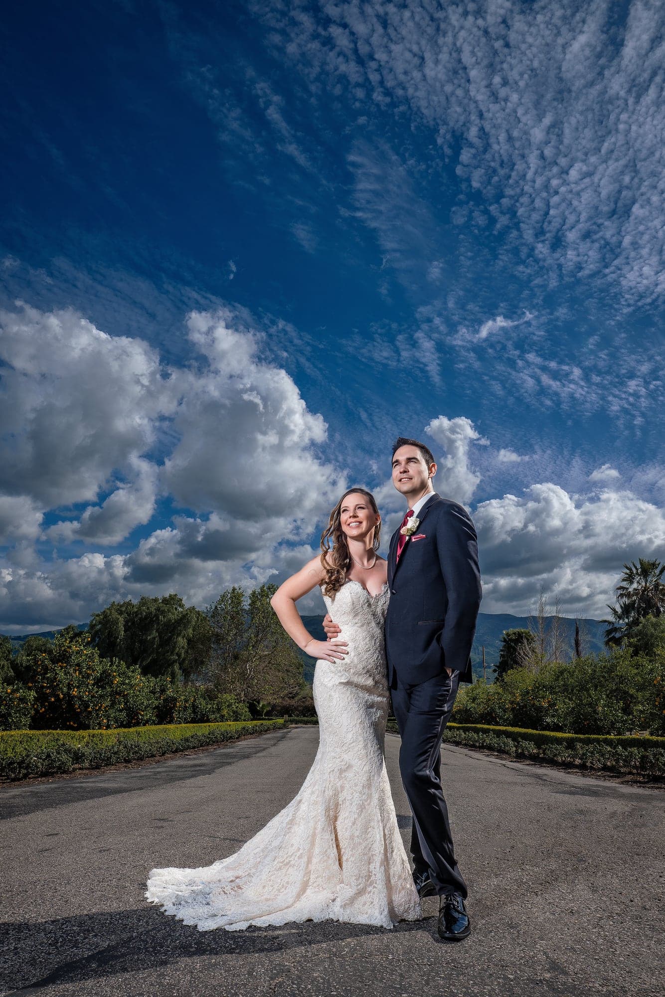 Chelsea and Greg beneath a dramatic sky outside Newhall Mansion