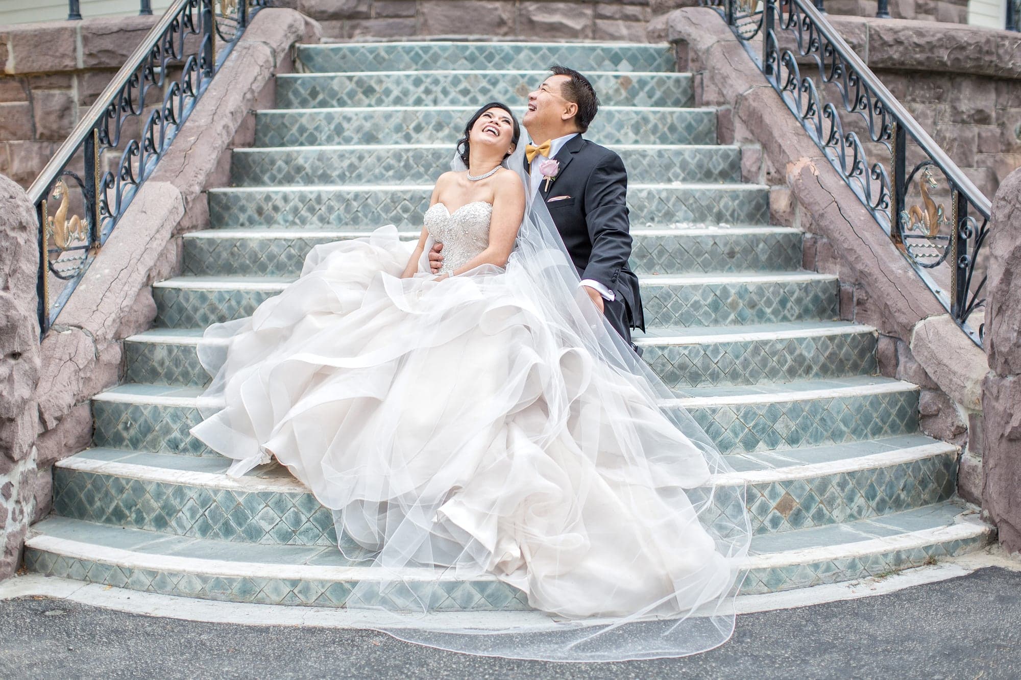Reyrata newlyweds on the grand stairs at Newhall Mansion