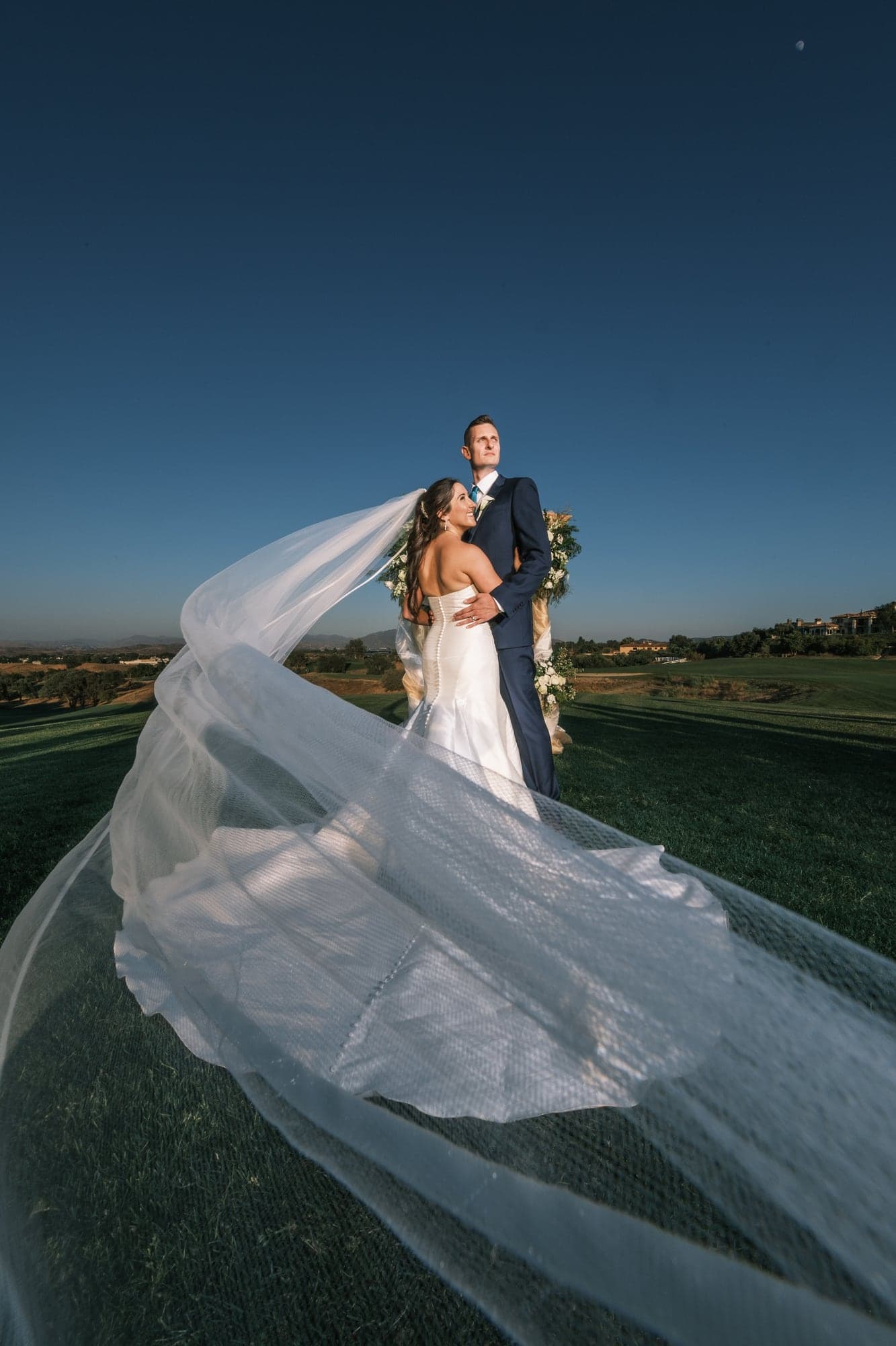 Katherine and Andrew beneath a flowing veil at sunset
