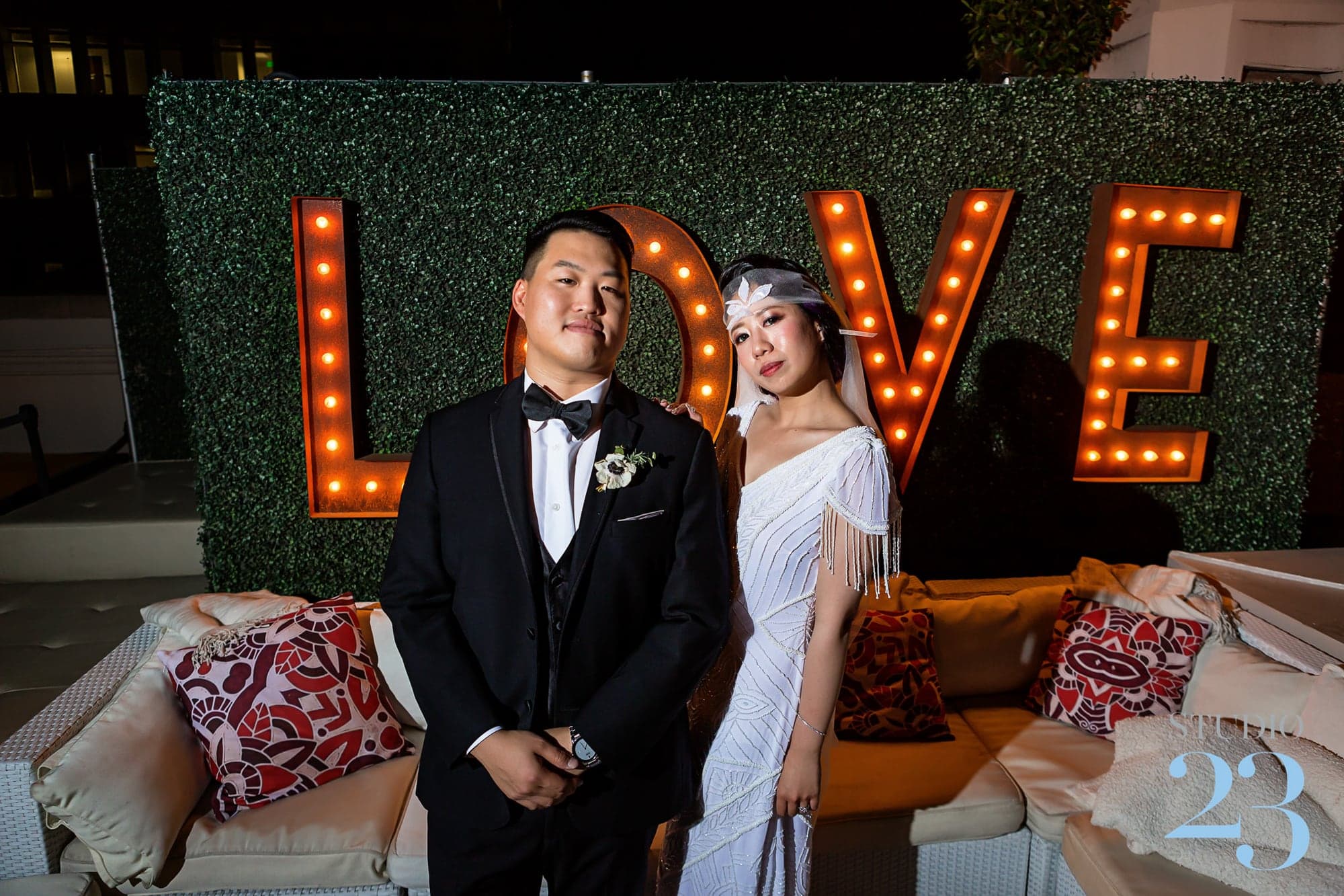 The Change couple beside illuminated marquee letters at the Oviatt Penthouse