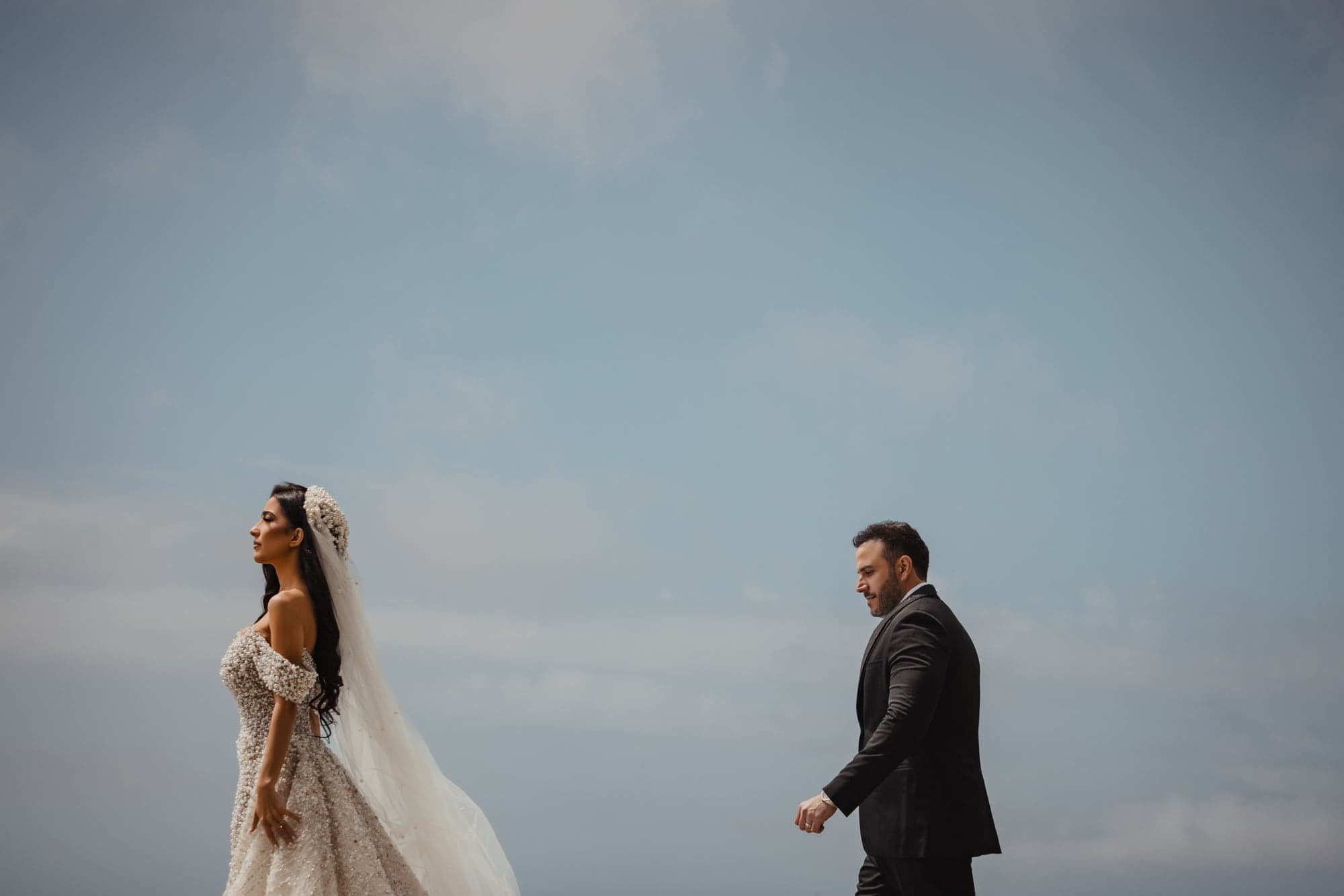 Julian and Sylva embracing beneath a dramatic cloudy sky before their Republic reception