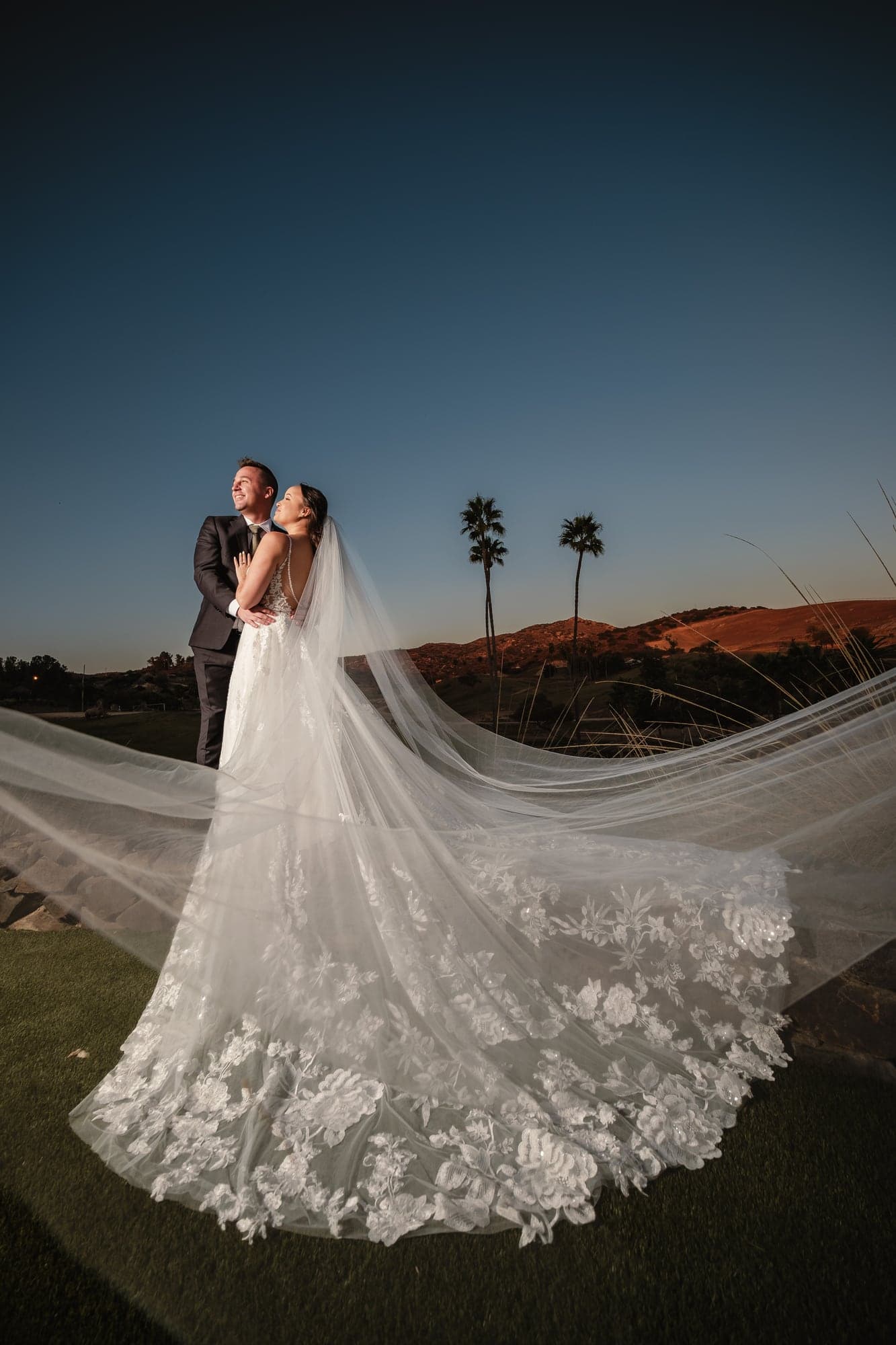 Leslie and Paul embracing beneath the evening sky at San Diego Safari Park
