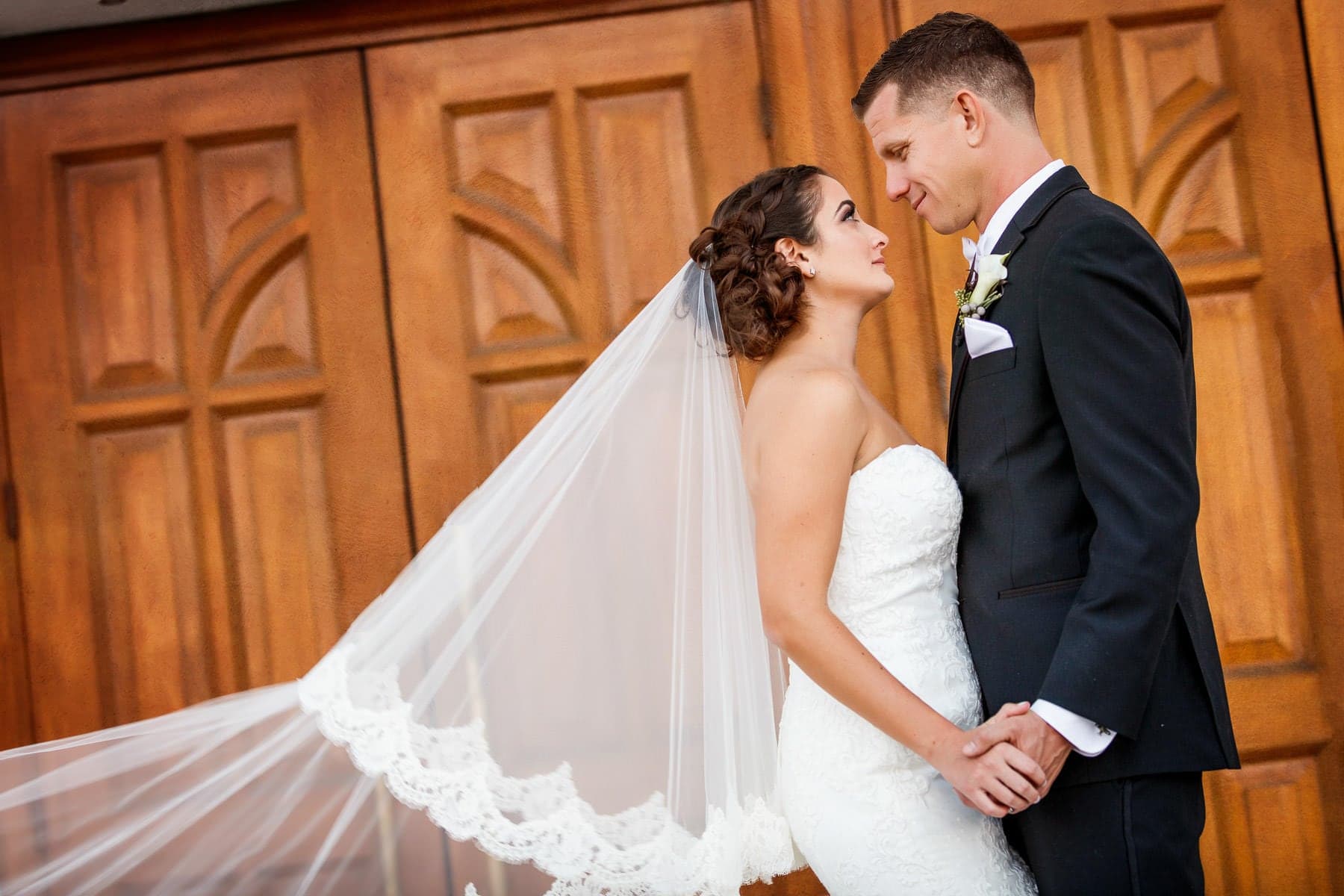 Nikki and Matt together before carved church doors at St. Nicholas