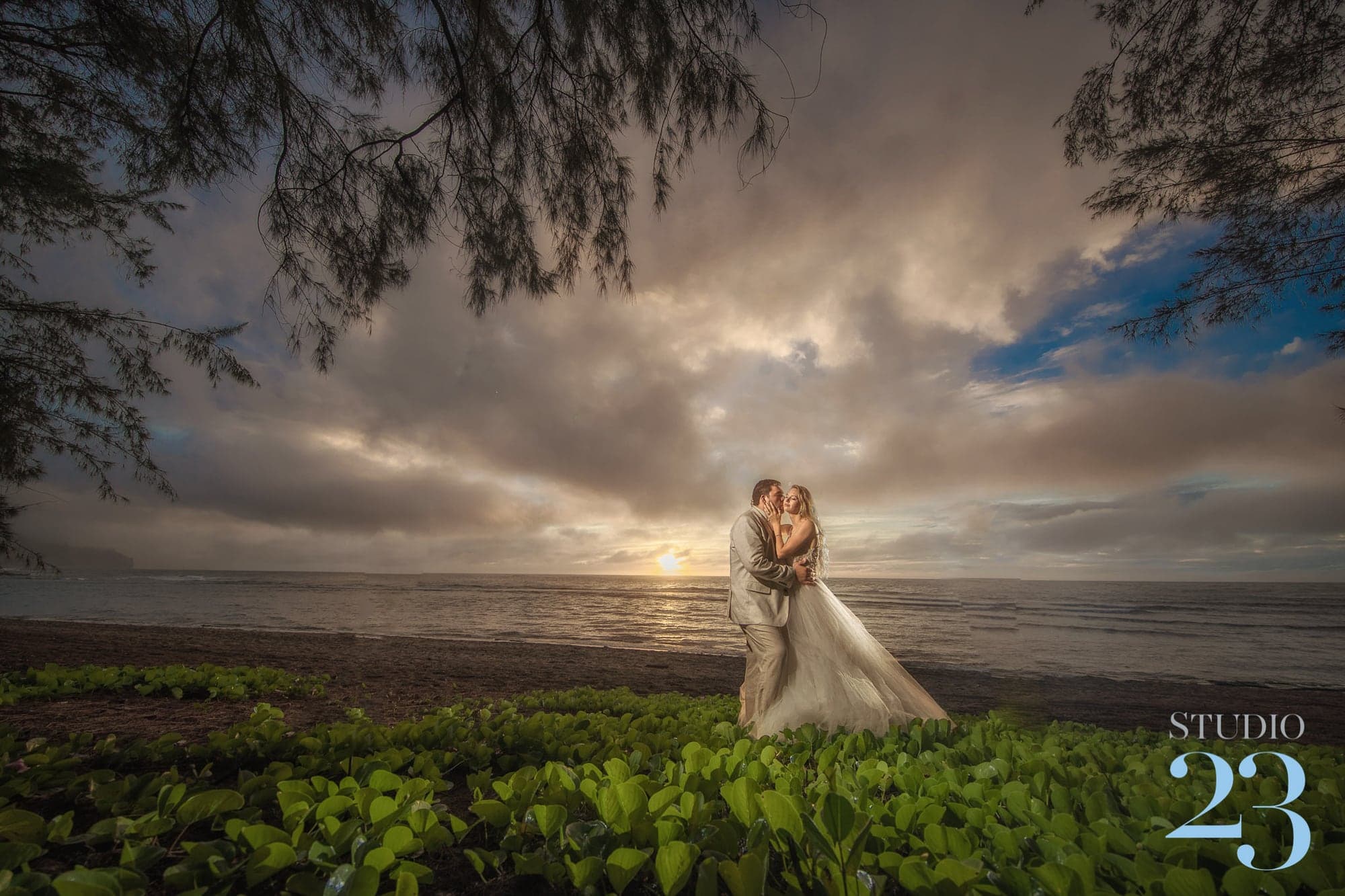 Ashley and Marco beneath a dramatic Kauai sunset