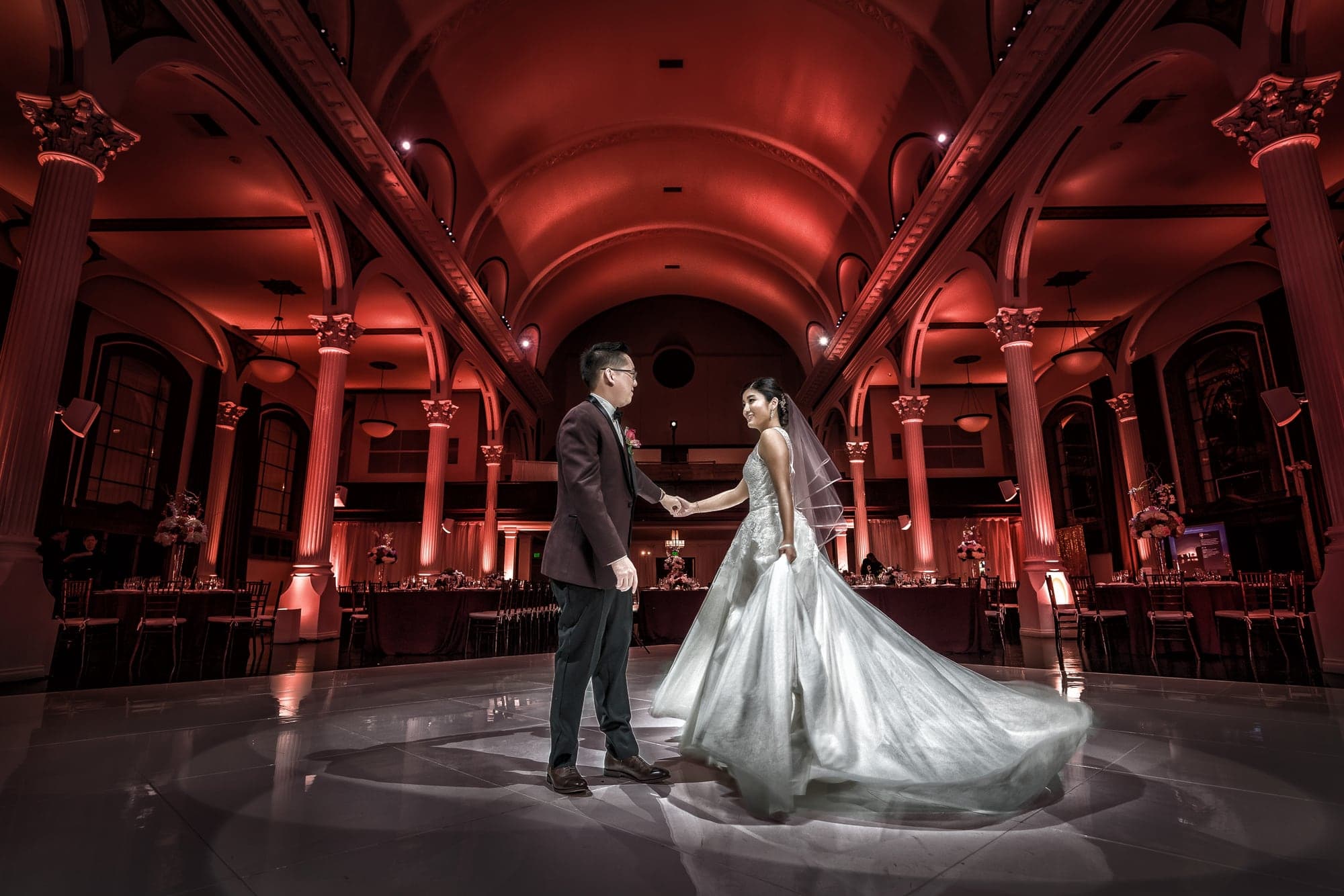 Andrea and David dancing inside red-lit Vibiana