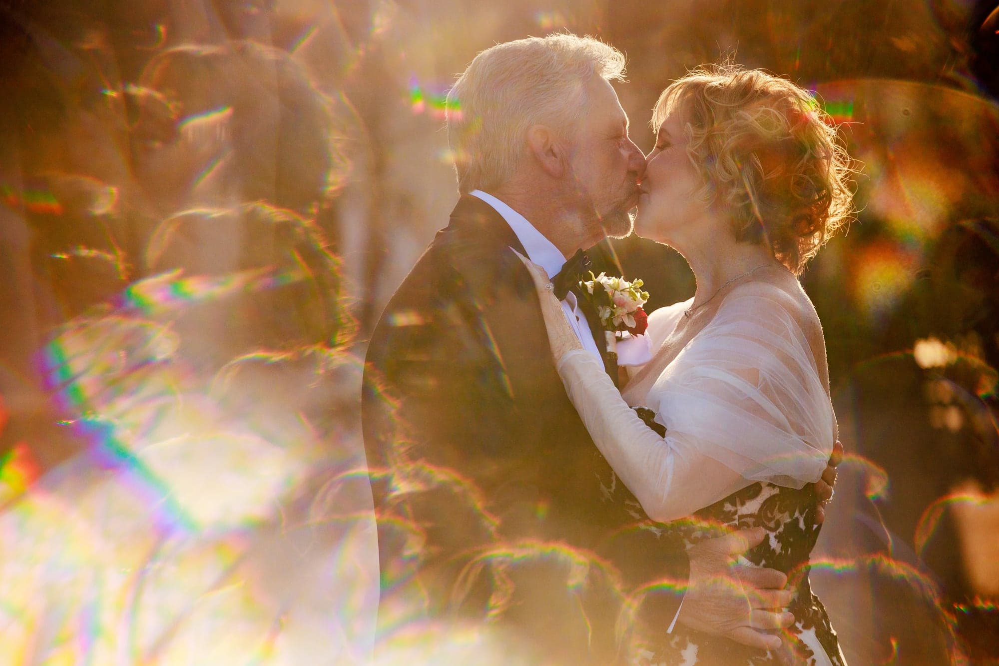 Donna and Greg sharing a kiss in warm garden light at Westlake Village Inn