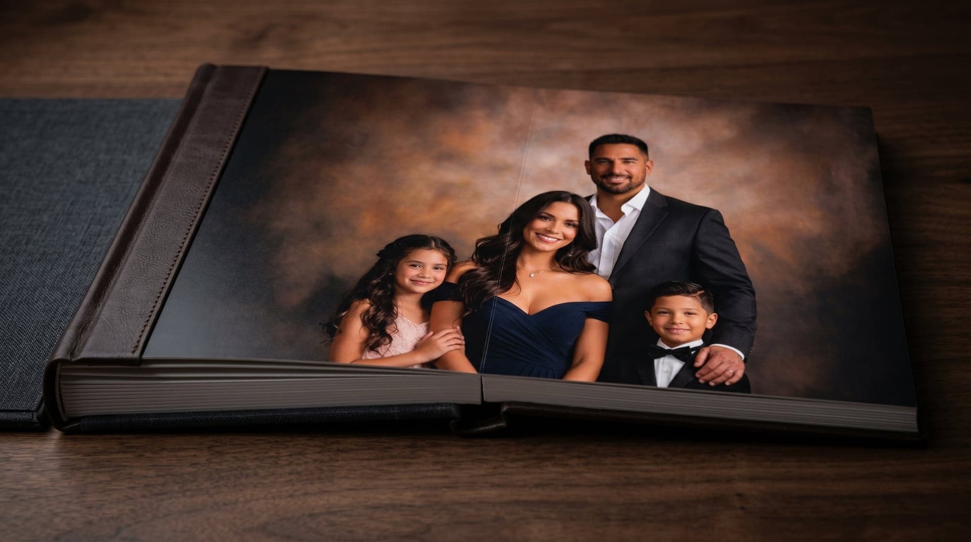 Open flush-mount album with a family portrait spread, on dark walnut