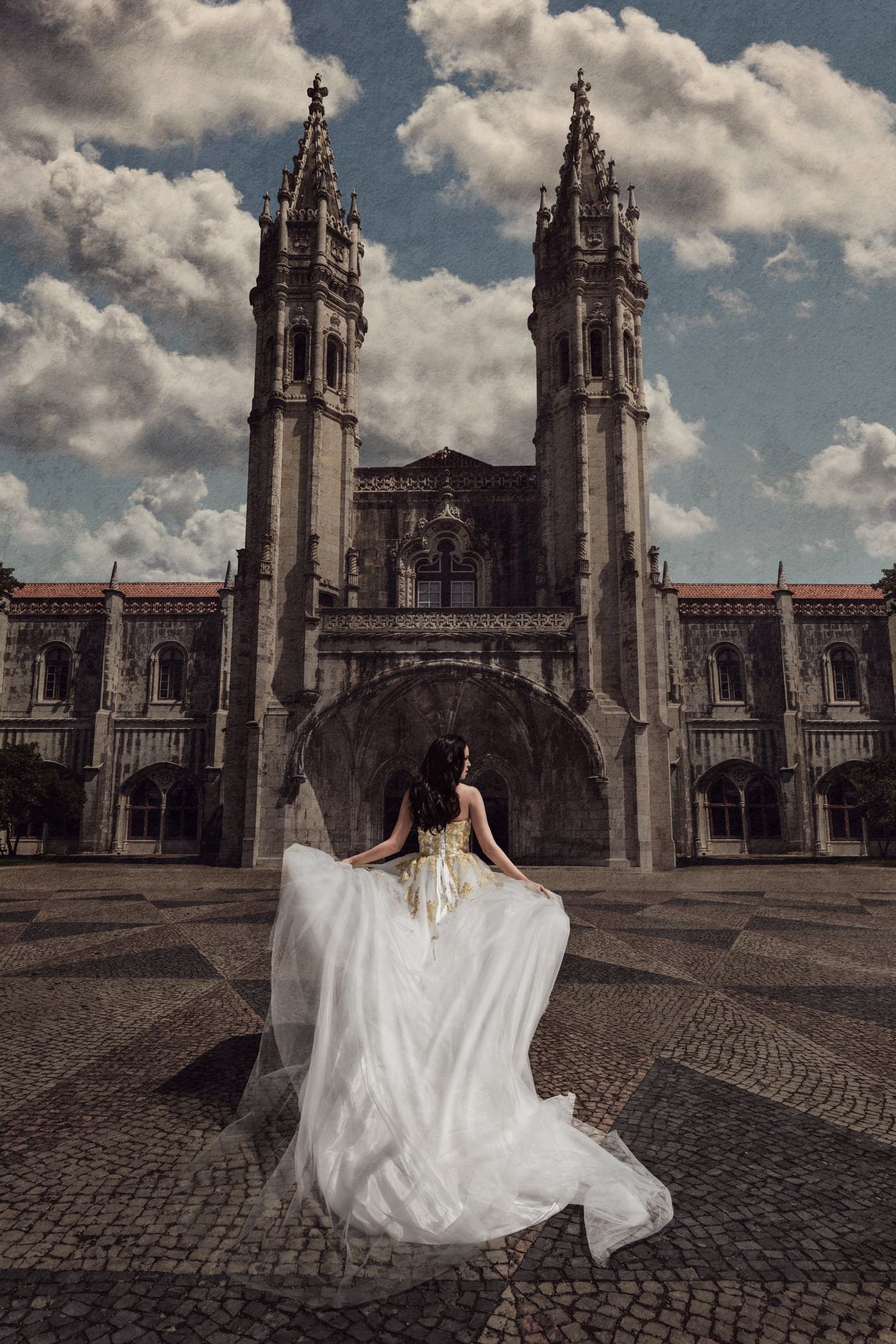 A wedding couple embracing before ornate stone architecture in Portugal