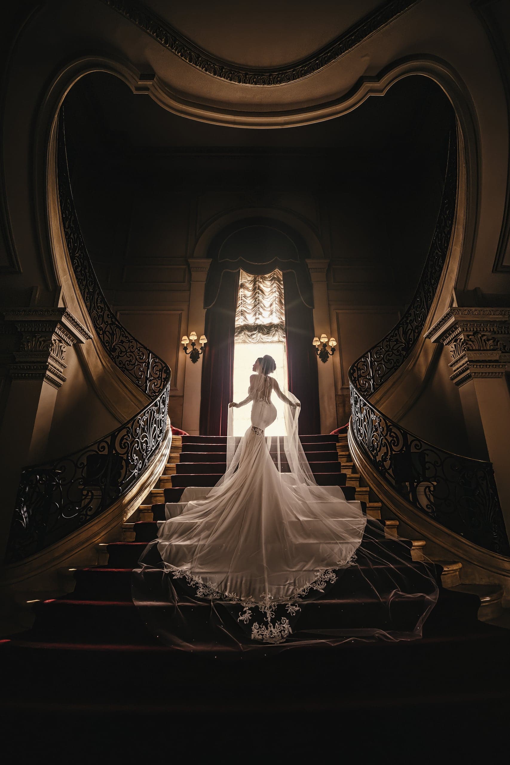 Bride on a grand staircase in stained-glass light